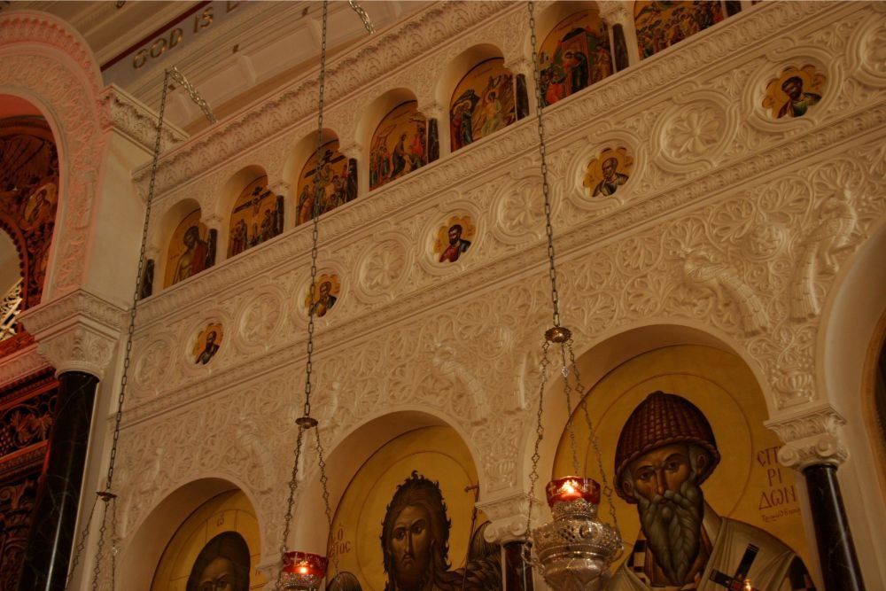 Ornate church interior with carved arches, painted icons, and warm lighting