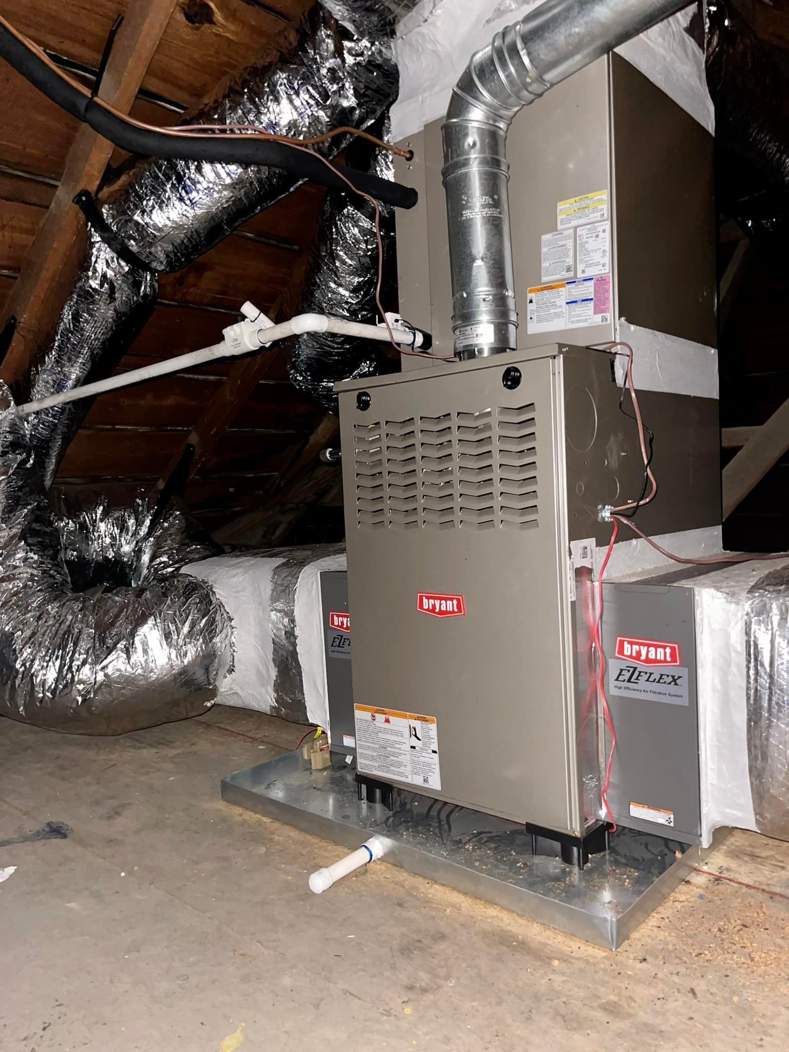 An air conditioner is sitting in the attic of a house.
