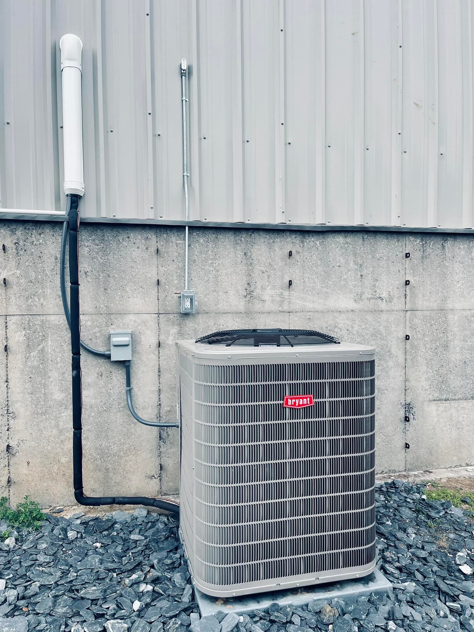 A large air conditioner is sitting outside of a building.