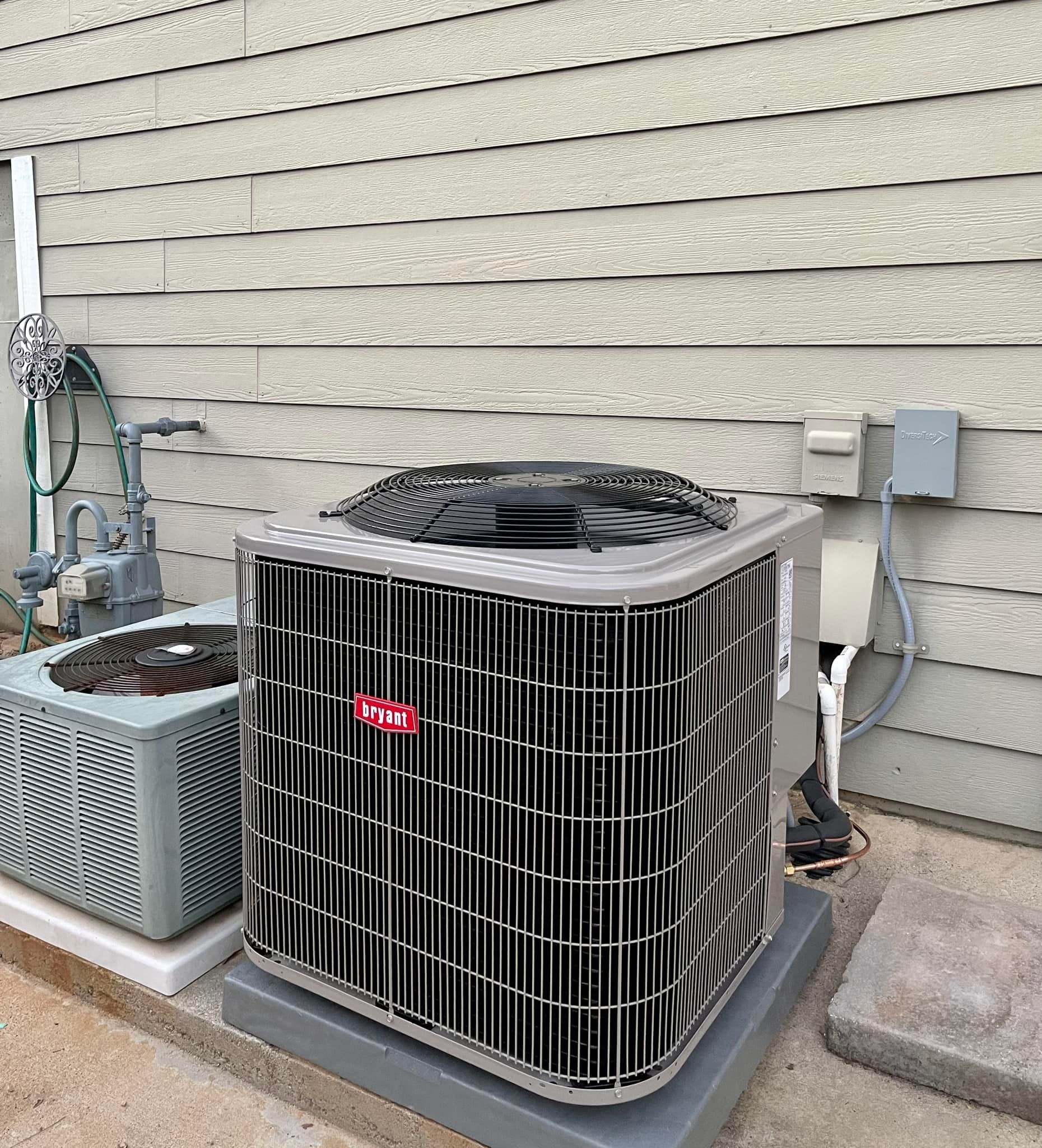 A large air conditioner is sitting on the side of a house.
