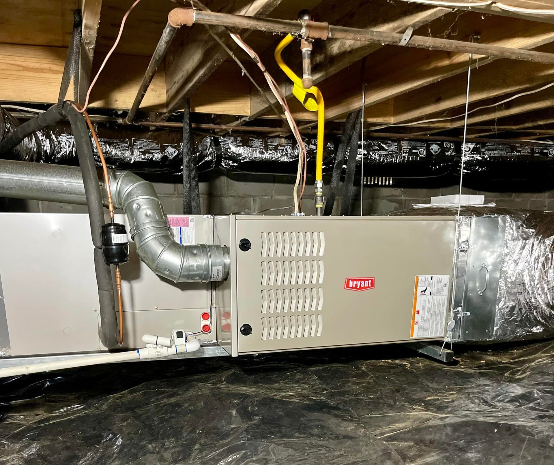 An air conditioner is hanging from the ceiling of a basement.