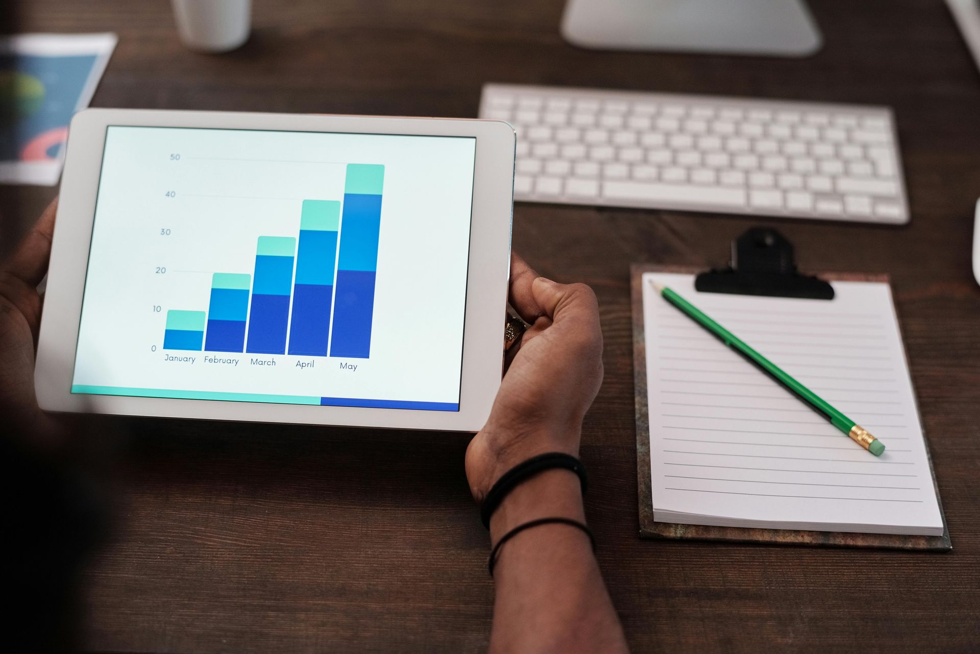 A person is holding a tablet with a graph on it.