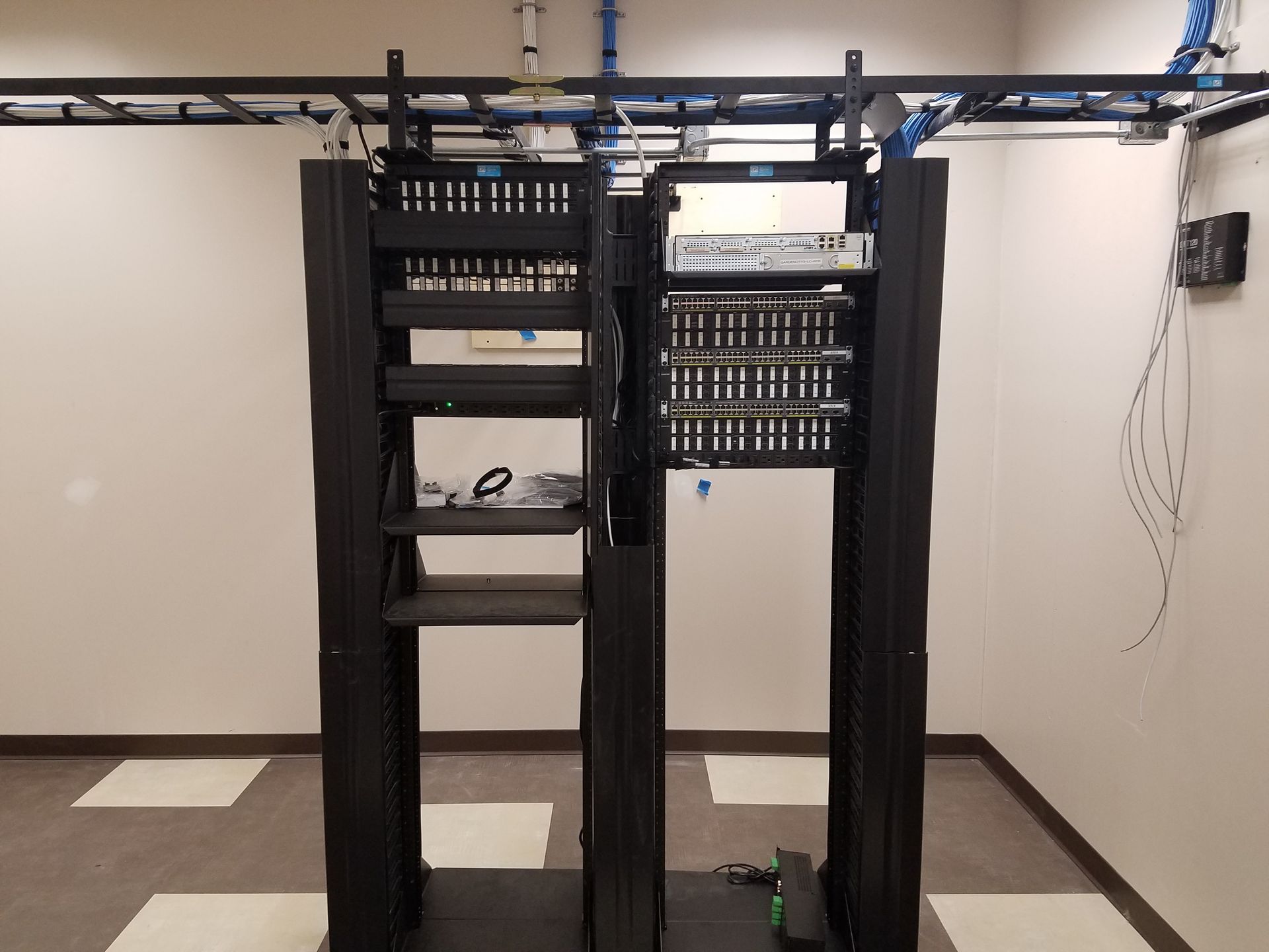 A server rack in a room with a white wall