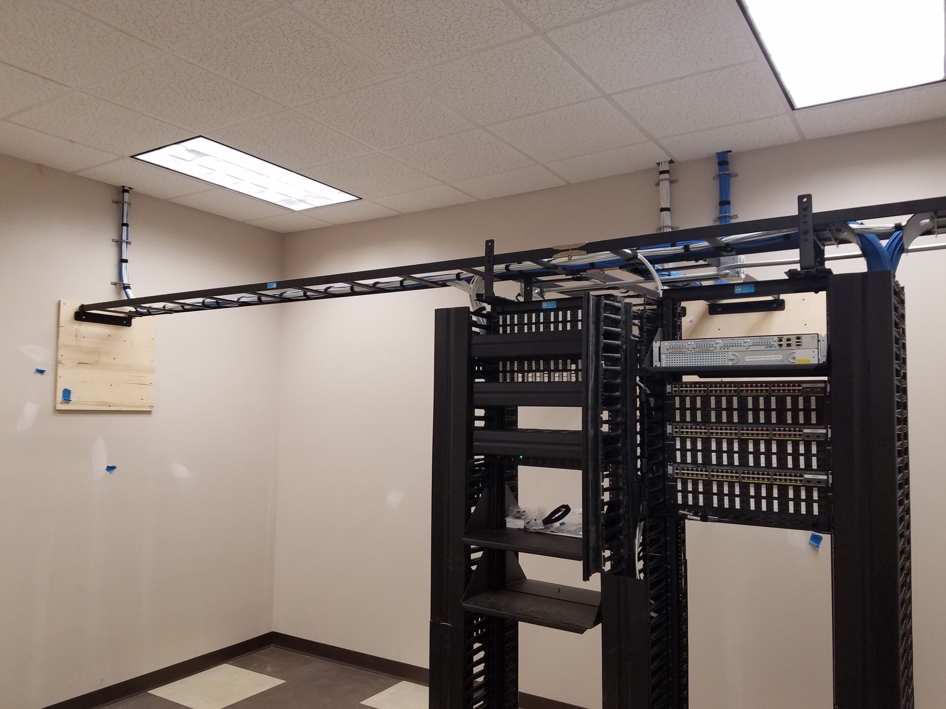 A room with a lot of racks and wires hanging from the ceiling
