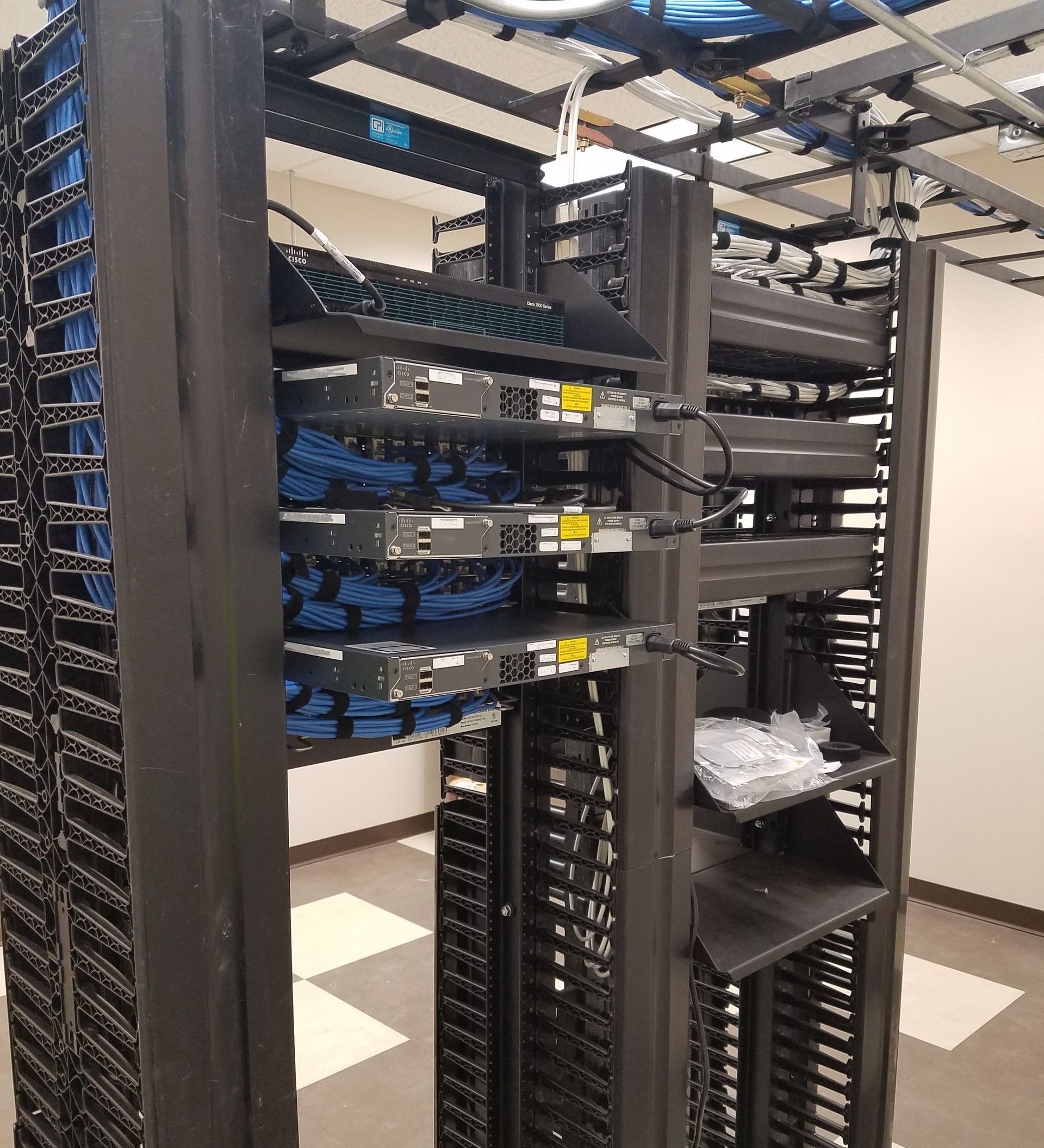 A server rack filled with lots of wires in a server room.