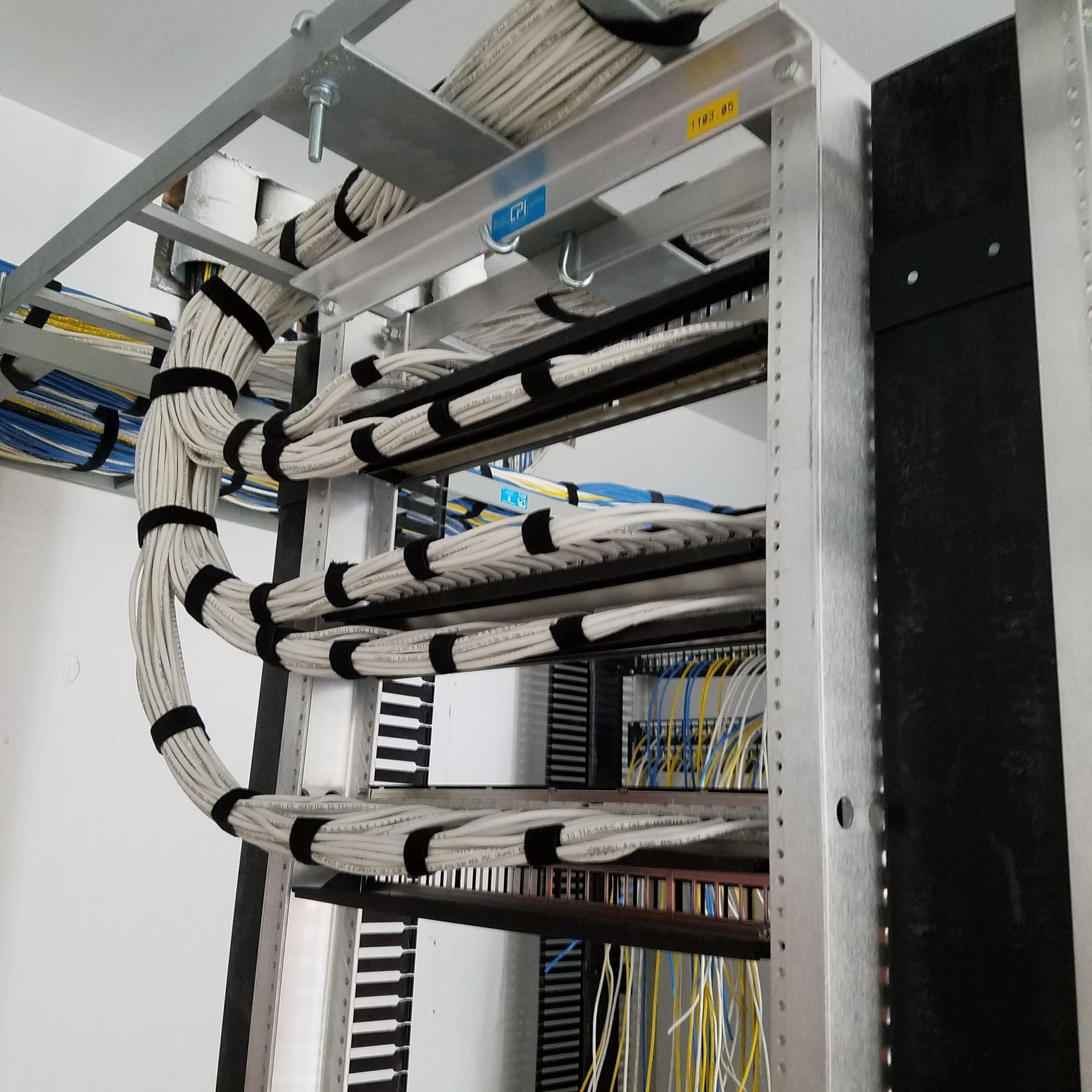 A bunch of wires are hanging from a metal rack