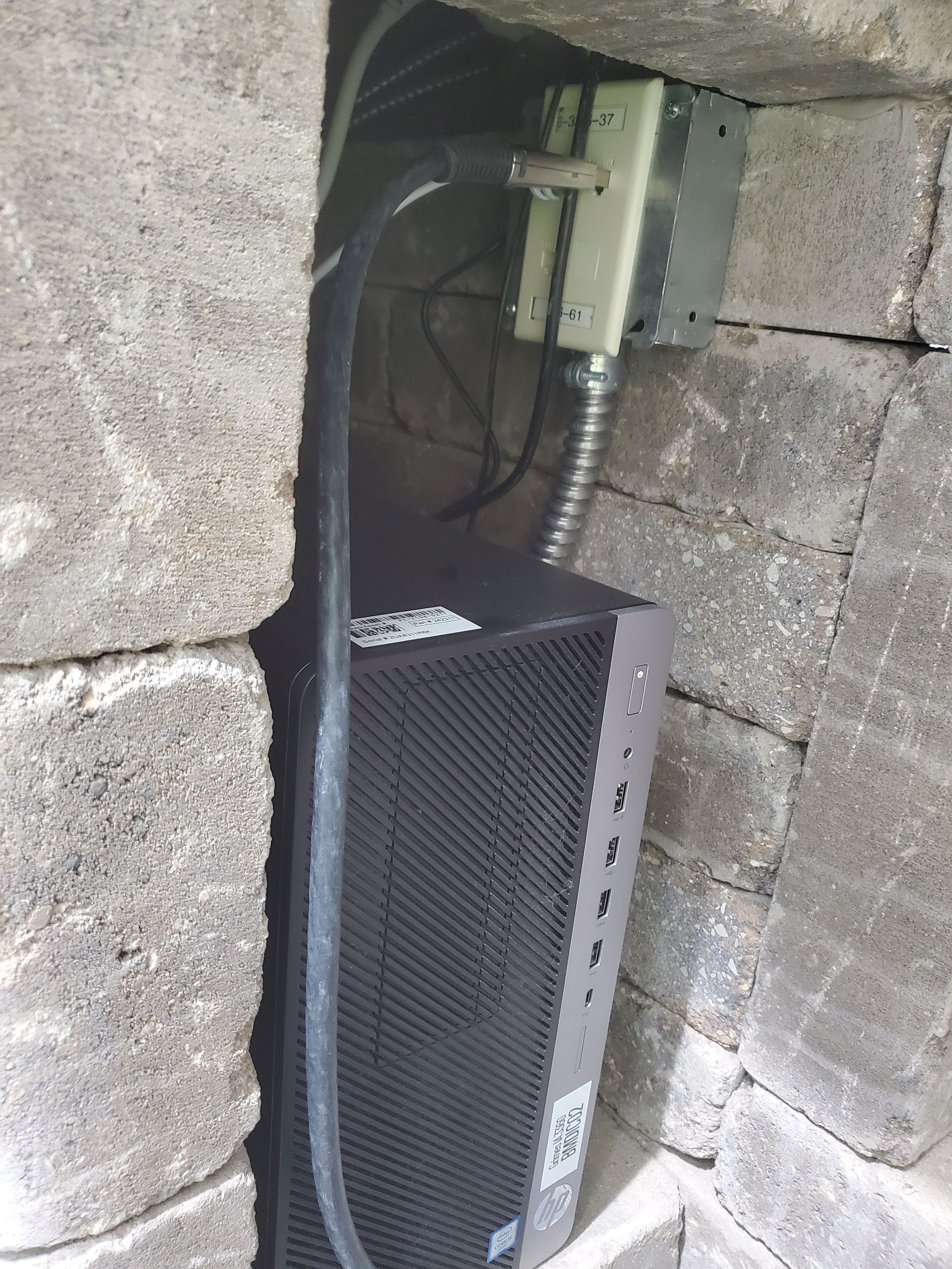 A computer is plugged into a brick wall.