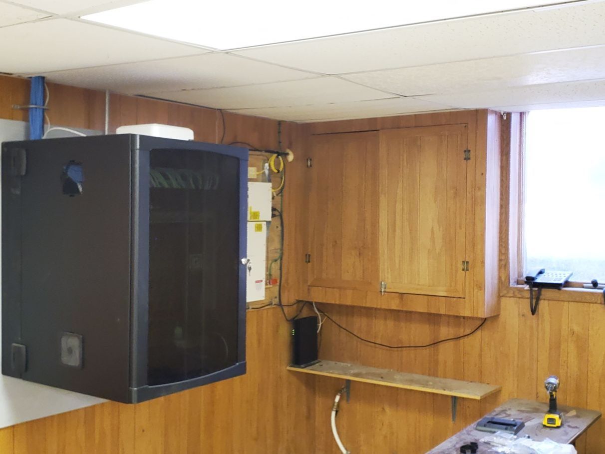 A room with wood paneling and a black box on the wall.
