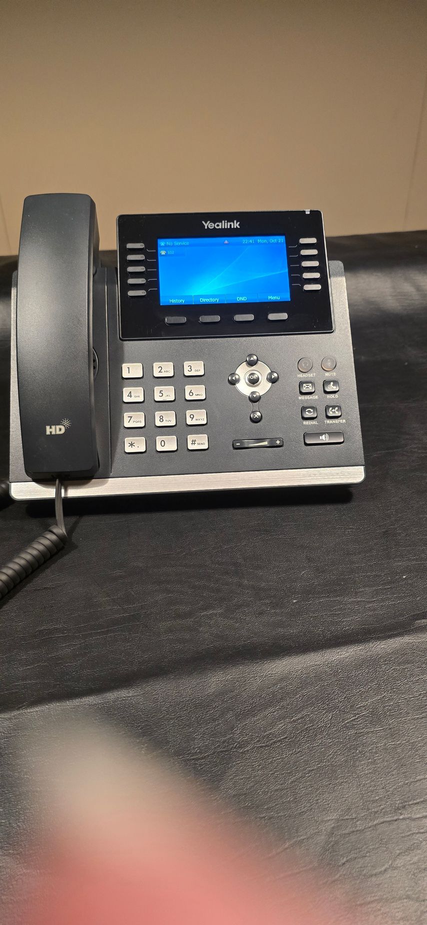 A telephone with a blue screen is sitting on a table.