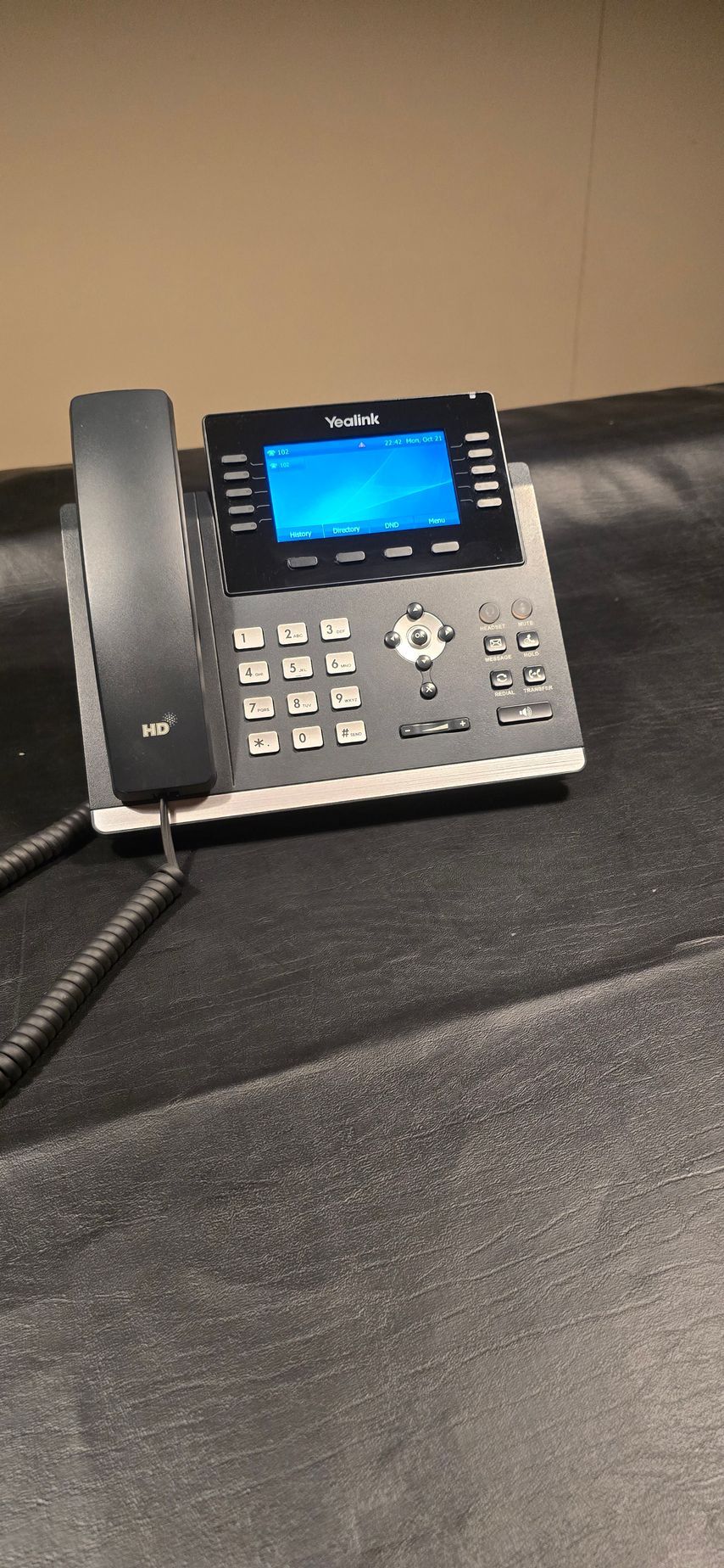 A telephone with a blue screen is sitting on a table.
