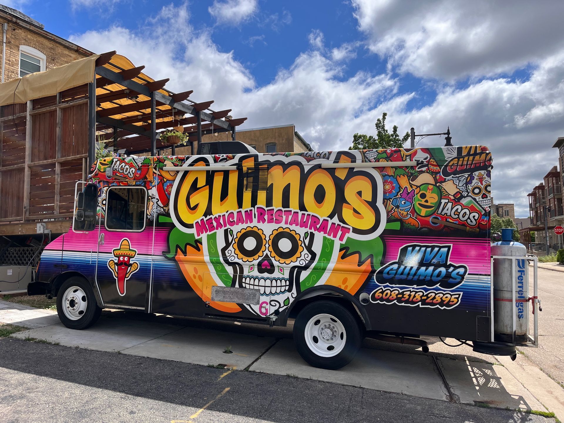 A colorful food truck is parked on the side of the road.