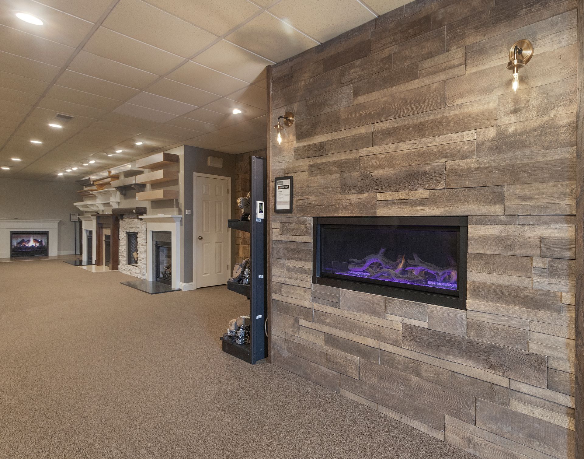 Spacious lobby with carpet, wood-paneled wall fireplace, and recessed ceiling lights.