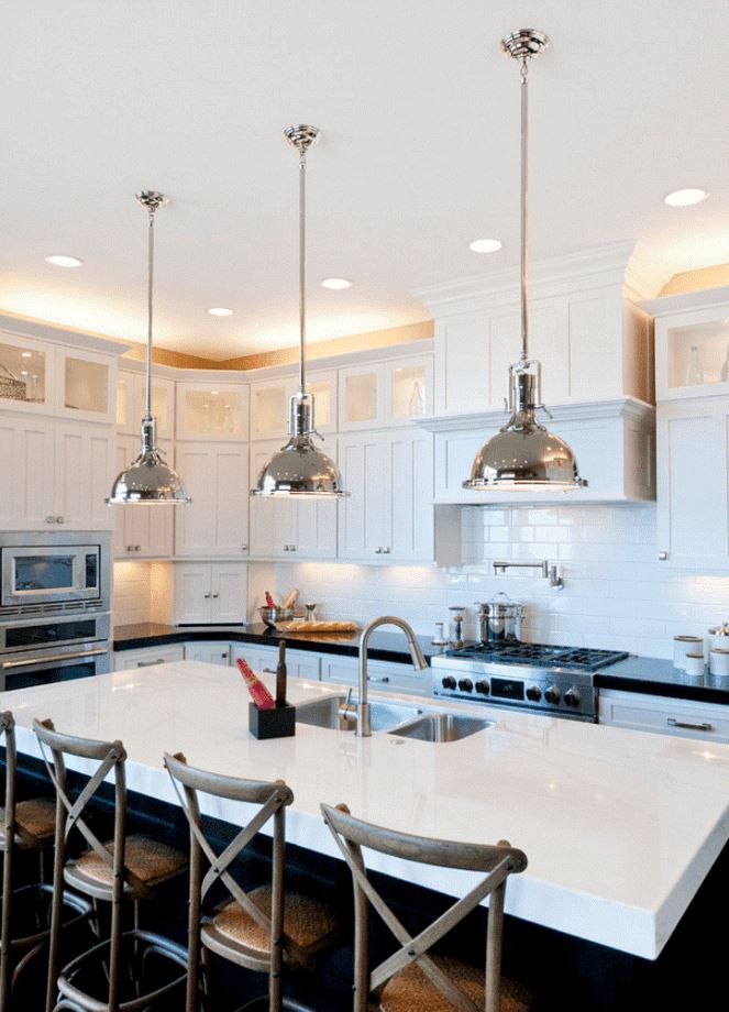 Bright white modern kitchen with a large island, pendant lights, and stainless steel appliances