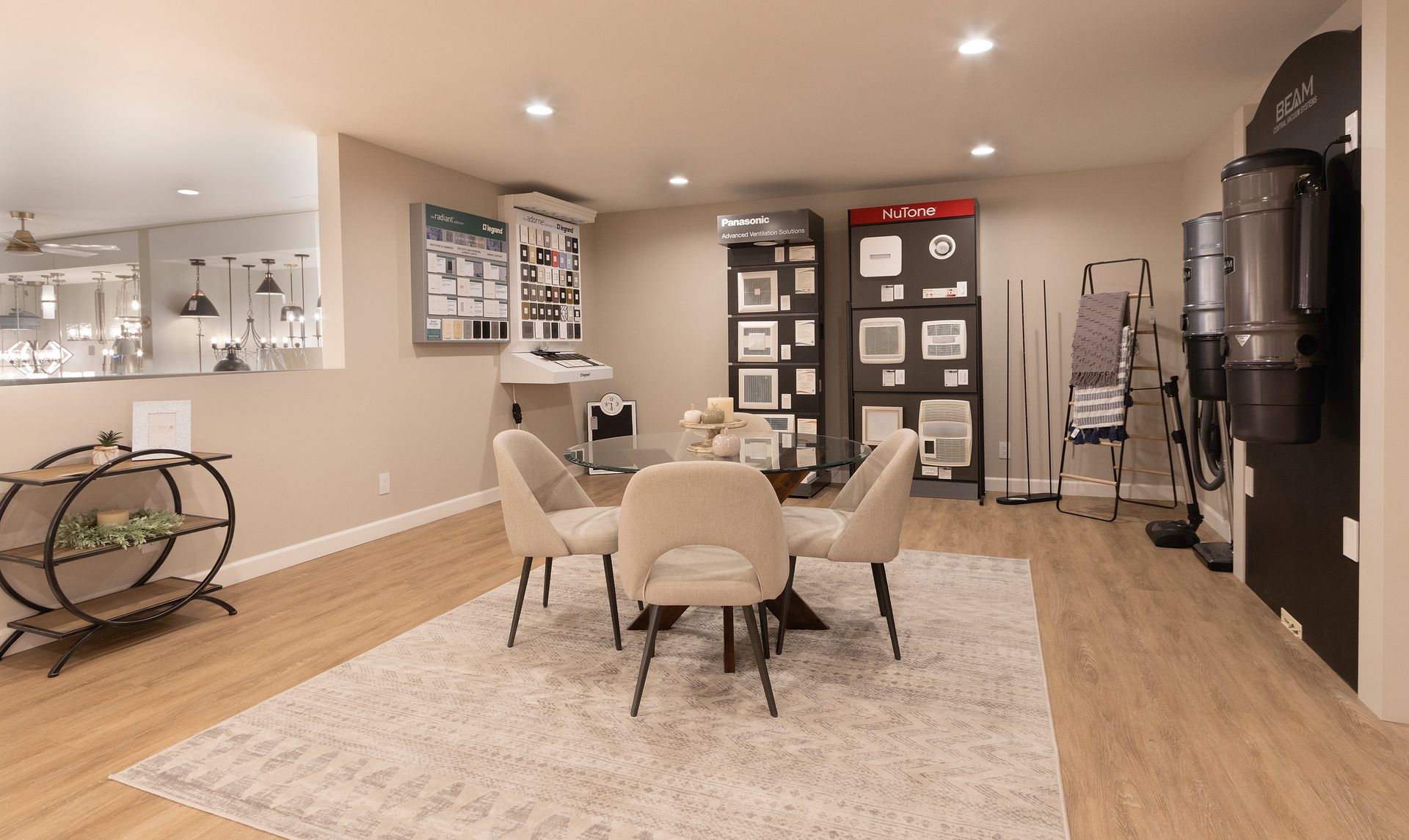 Modern home office with a round table, chairs, wall art, and a coffee station in a bright open room