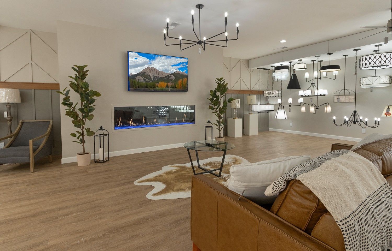 Modern living room with sectional sofa, mounted TV, chandelier, fireplace, and wood floors