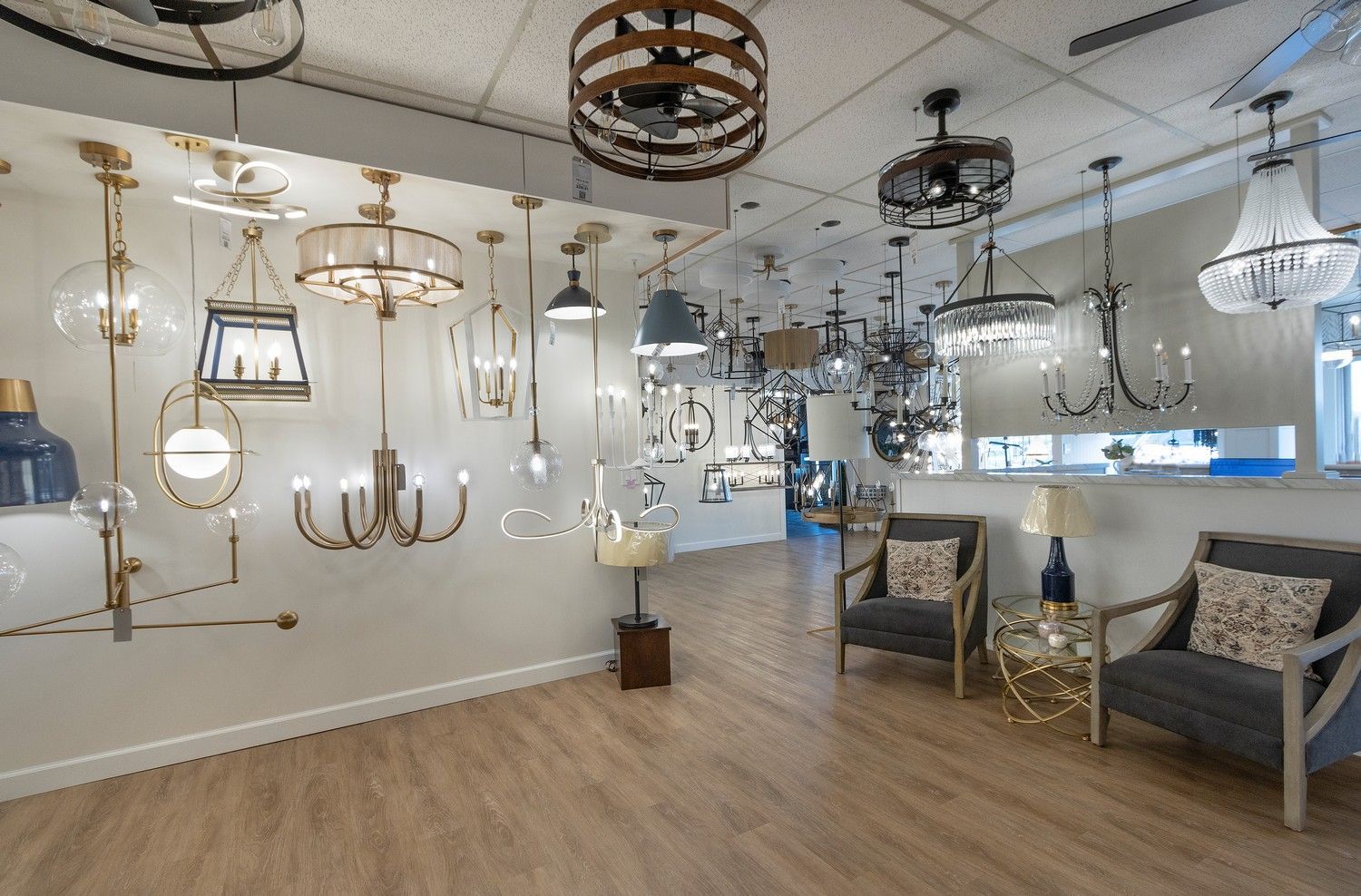 Showroom with hanging light fixtures, pendant lamps, and seating on wood floors