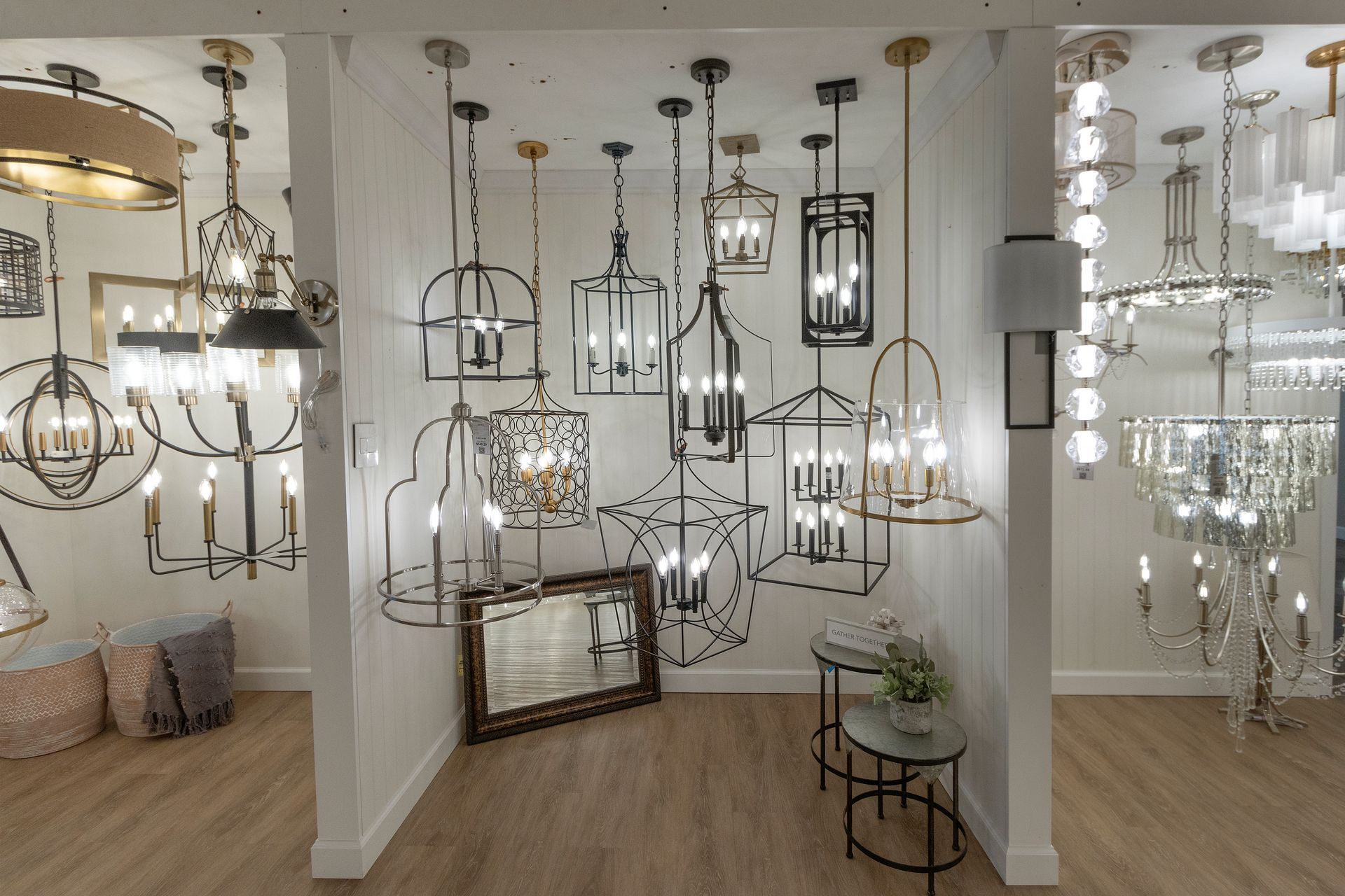 Showroom filled with hanging pendant lights and chandeliers in white and black finishes