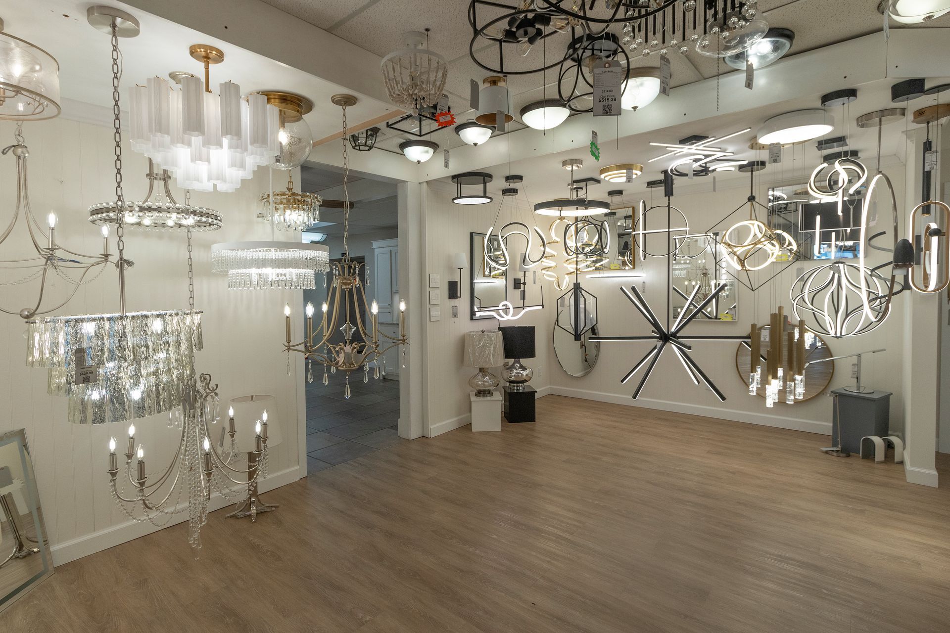 Bright showroom with many hanging modern chandeliers and pendant lights on display