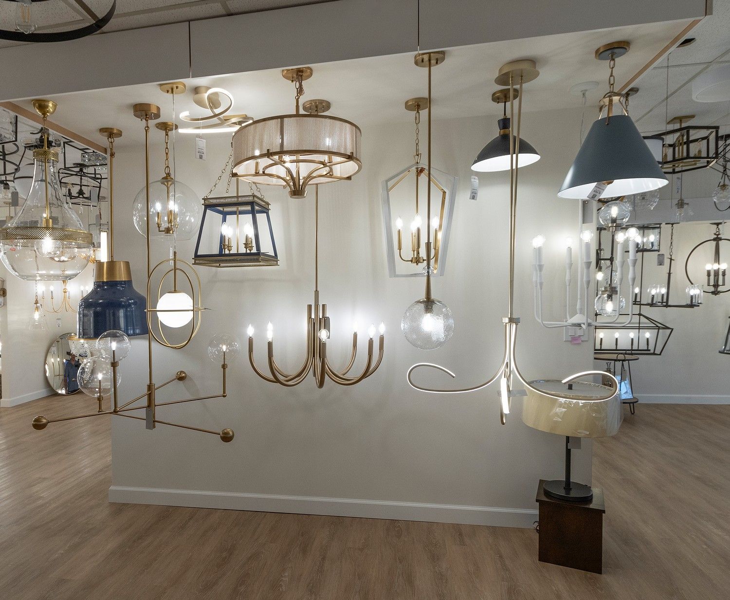 Assorted decorative ceiling lights and chandeliers displayed in a lighting showroom.