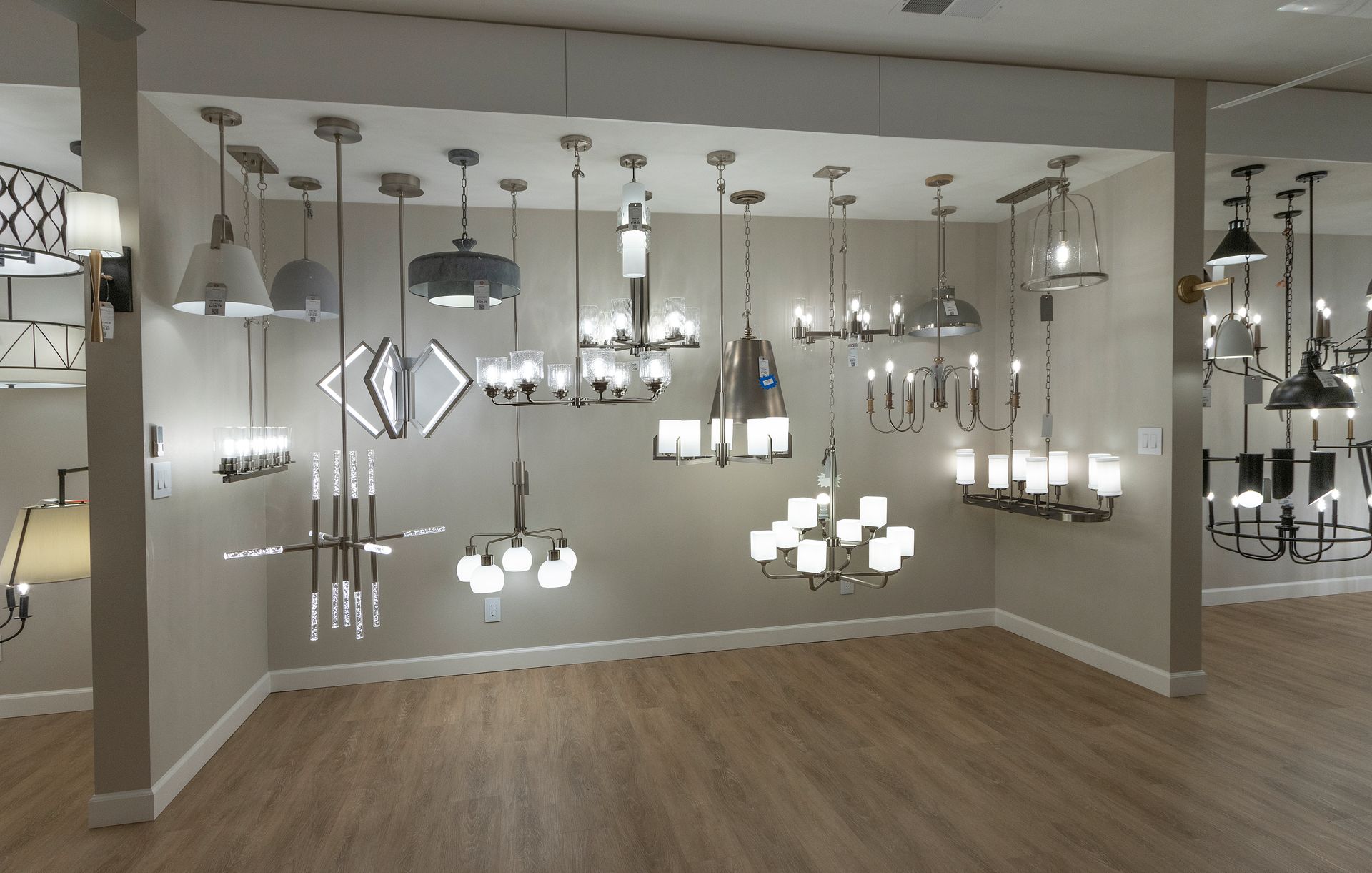 Showroom displaying multiple modern hanging light fixtures over wood flooring