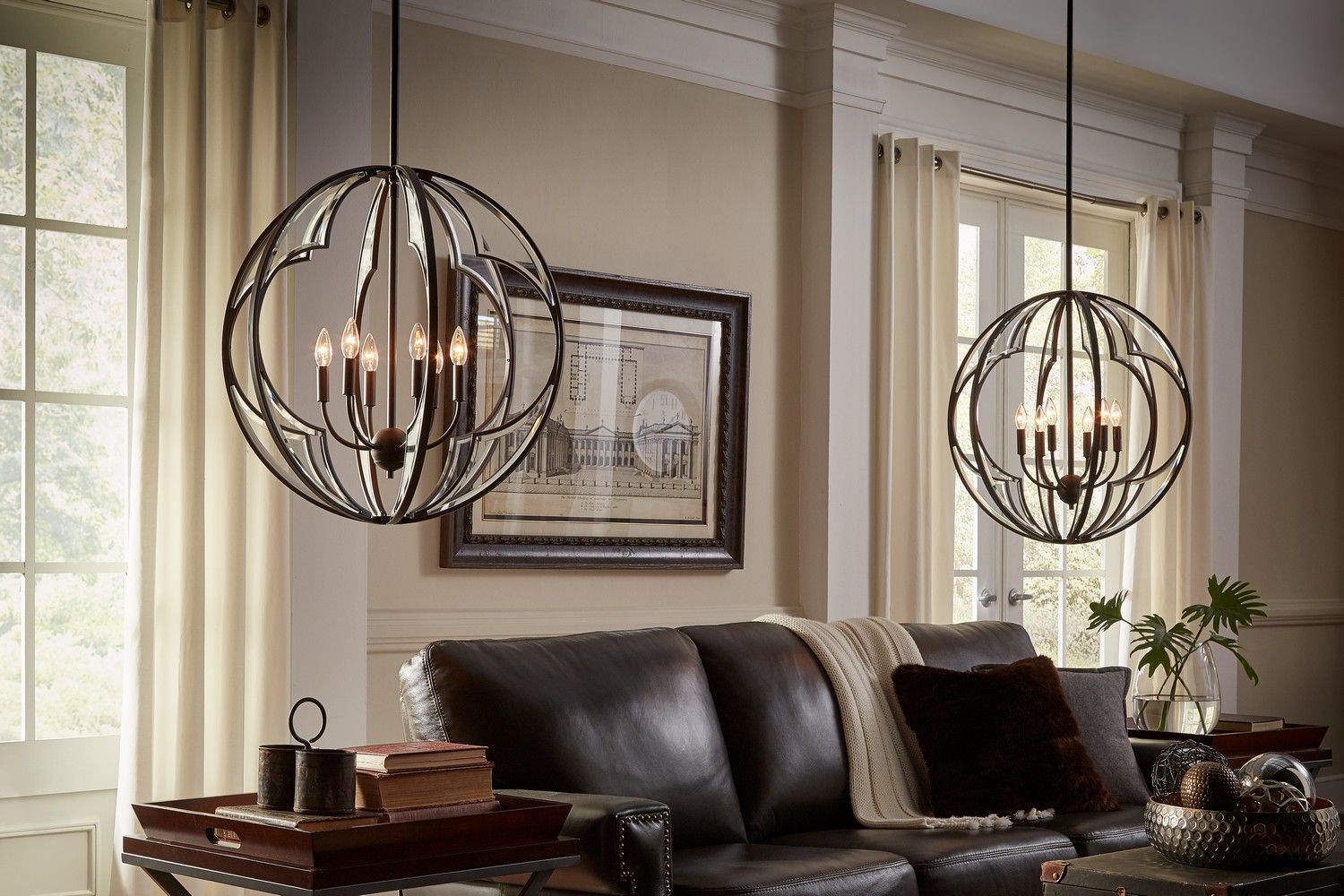 Elegant living room with dark leather sofa, globe pendant lights, framed art, and cream curtains