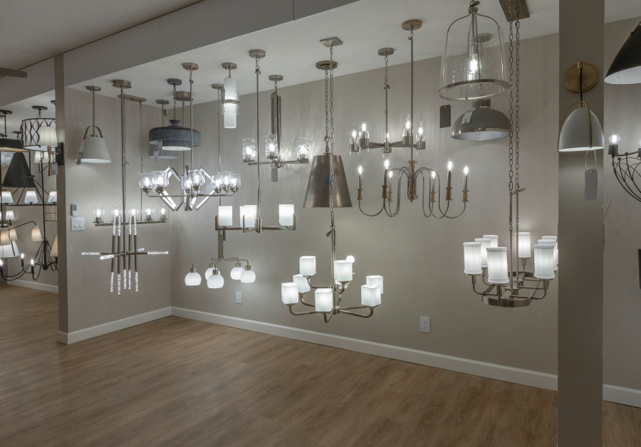 Display room showing a wall of hanging and ceiling light fixtures in a lighting showroom.
