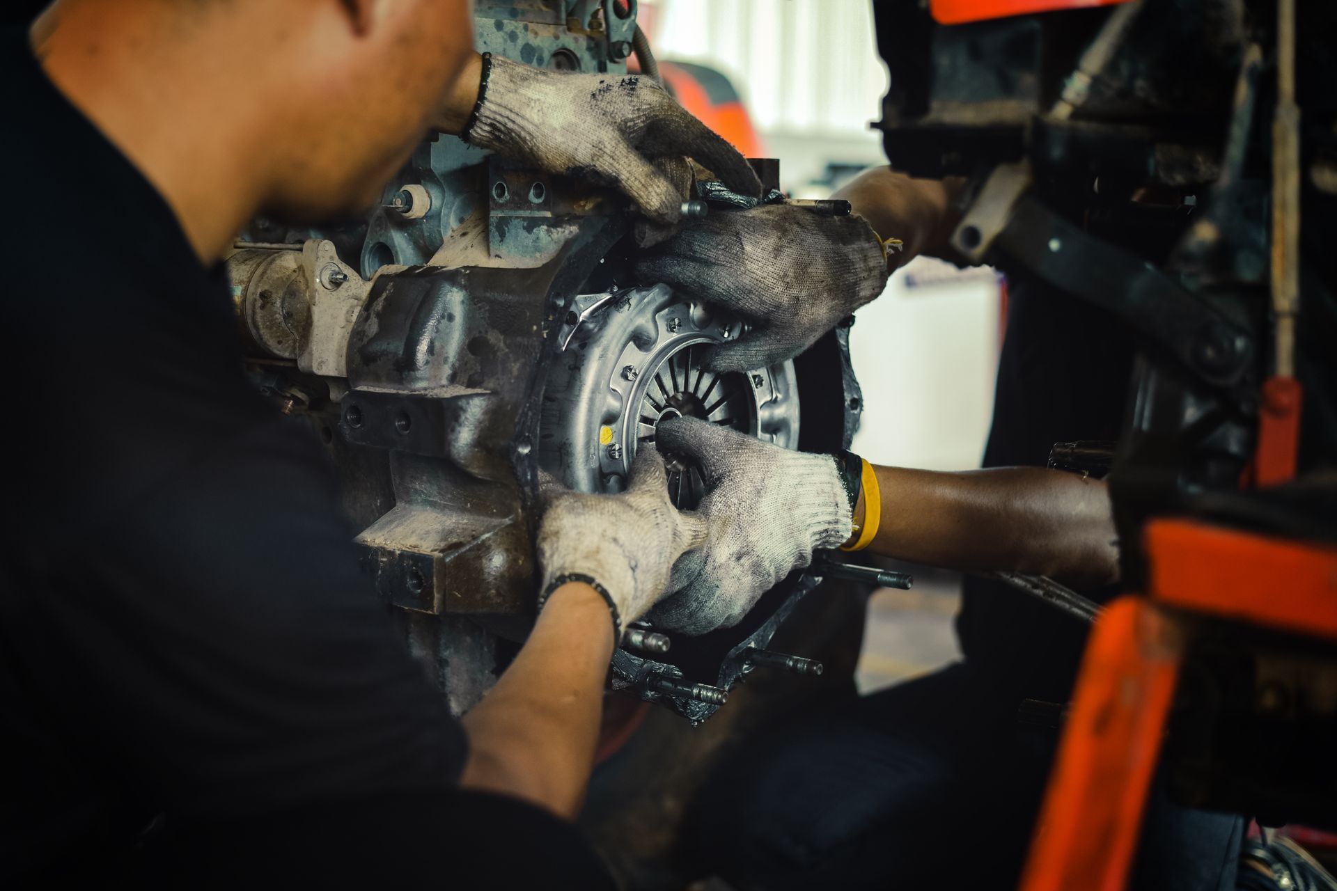 Mechanic using a wrench on a vehicle brake assembly in a workshop