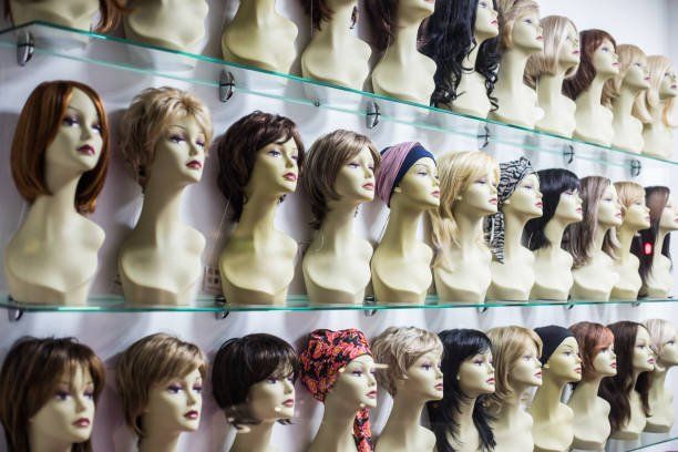 A row of mannequin heads with wigs on display in a store.