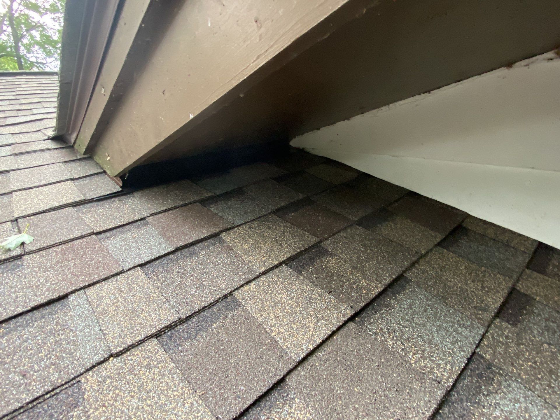 Roof shingles damaged by a gap under a slanted dormer wall