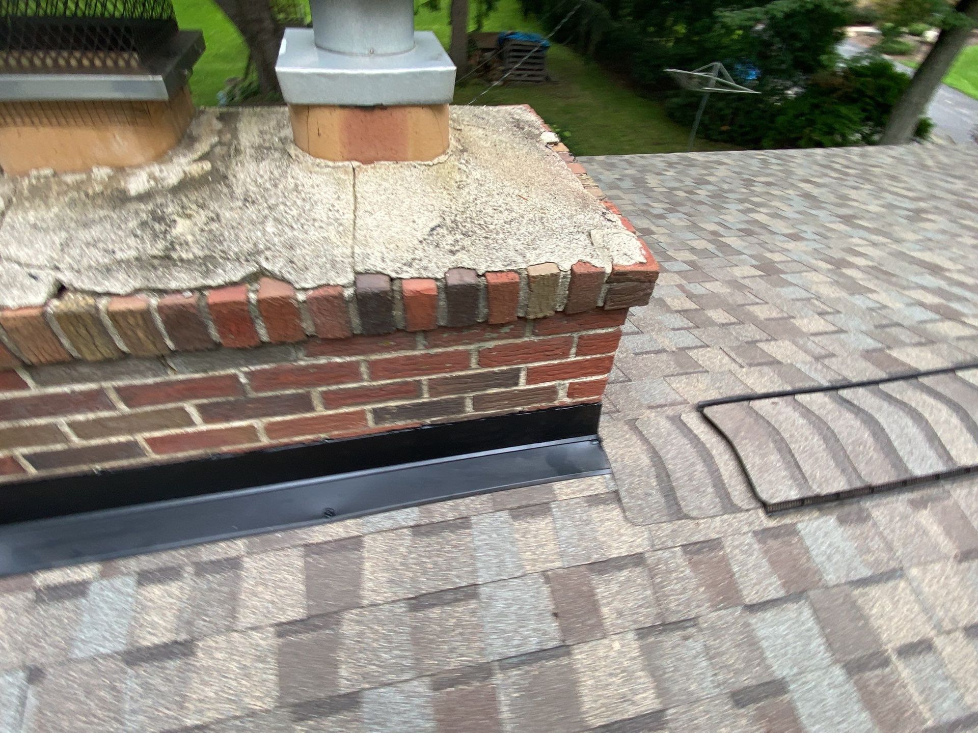Brick retaining wall beside patterned paver walkway and curved step, with planter above.