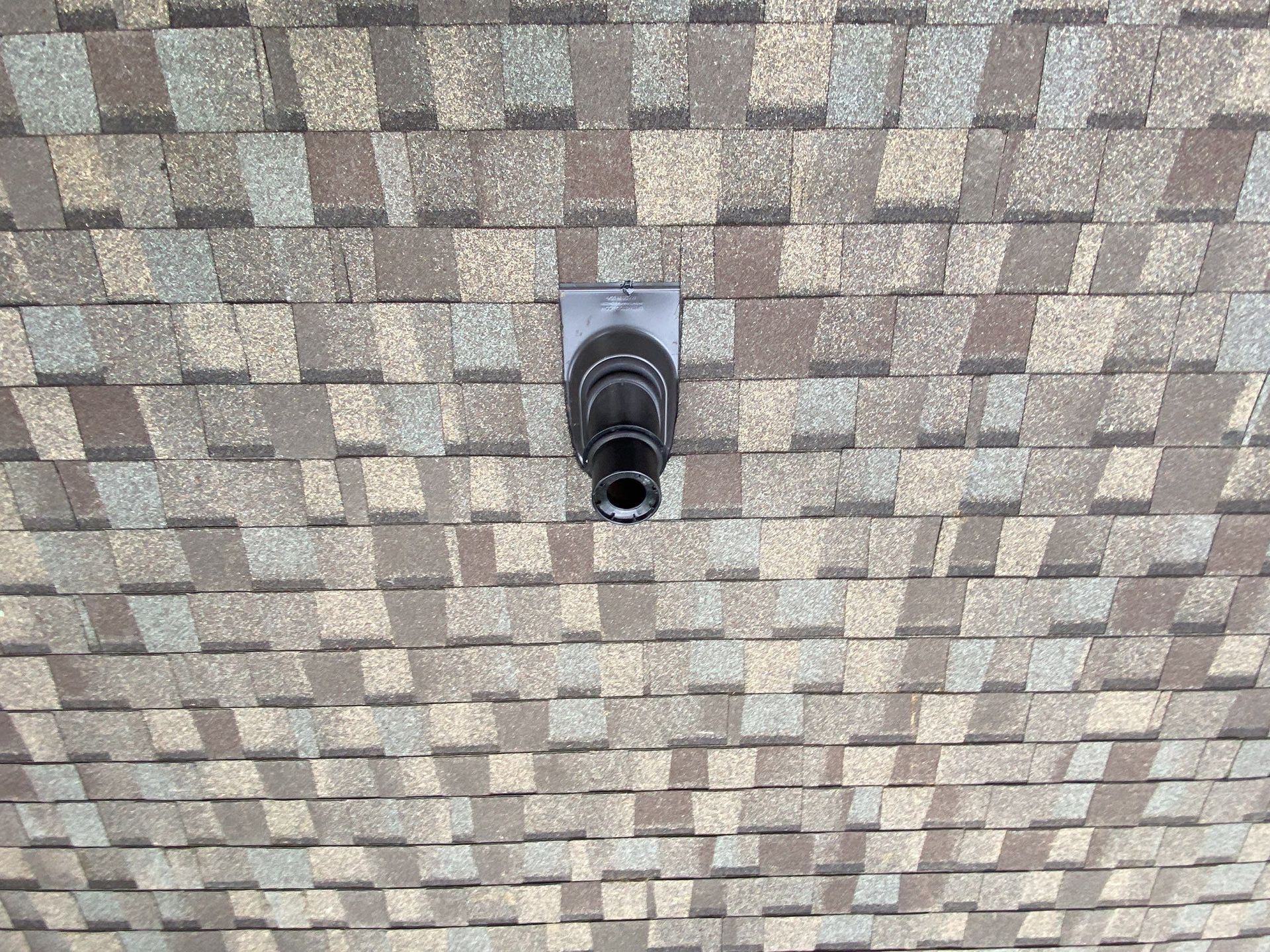 Black security camera mounted on a beige brick wall indoors.