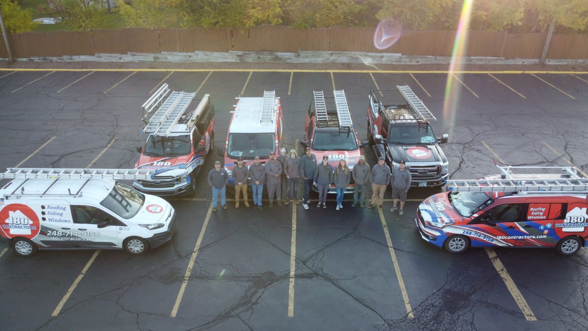 Fire trucks and response vans lined up in a parking lot with a group of people standing in front.