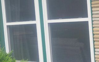 White-trimmed windows with dark blinds on a building exterior