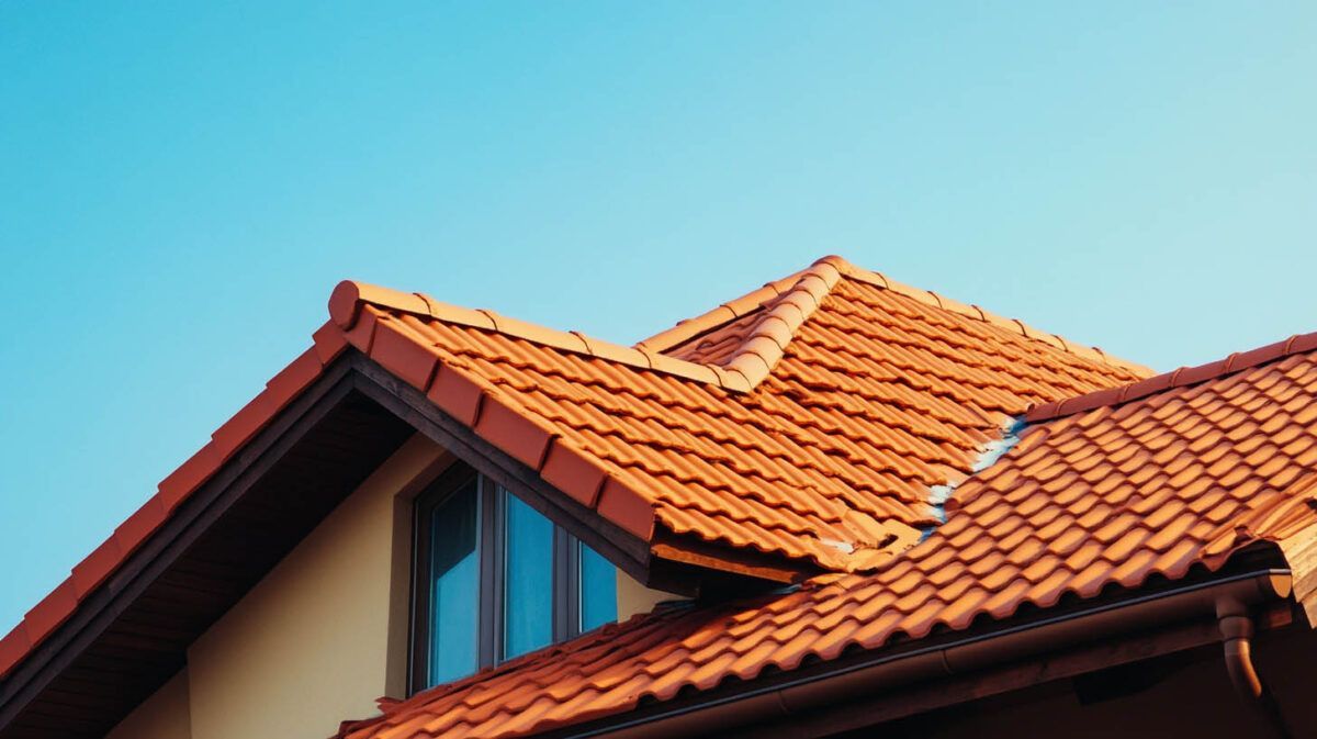 Orange-tiled house roof against a clear blue sky