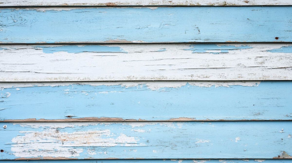 Weathered light blue and white painted wooden planks with peeling paint.