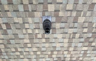 Close-up of a black security camera mounted on a tiled ceiling.