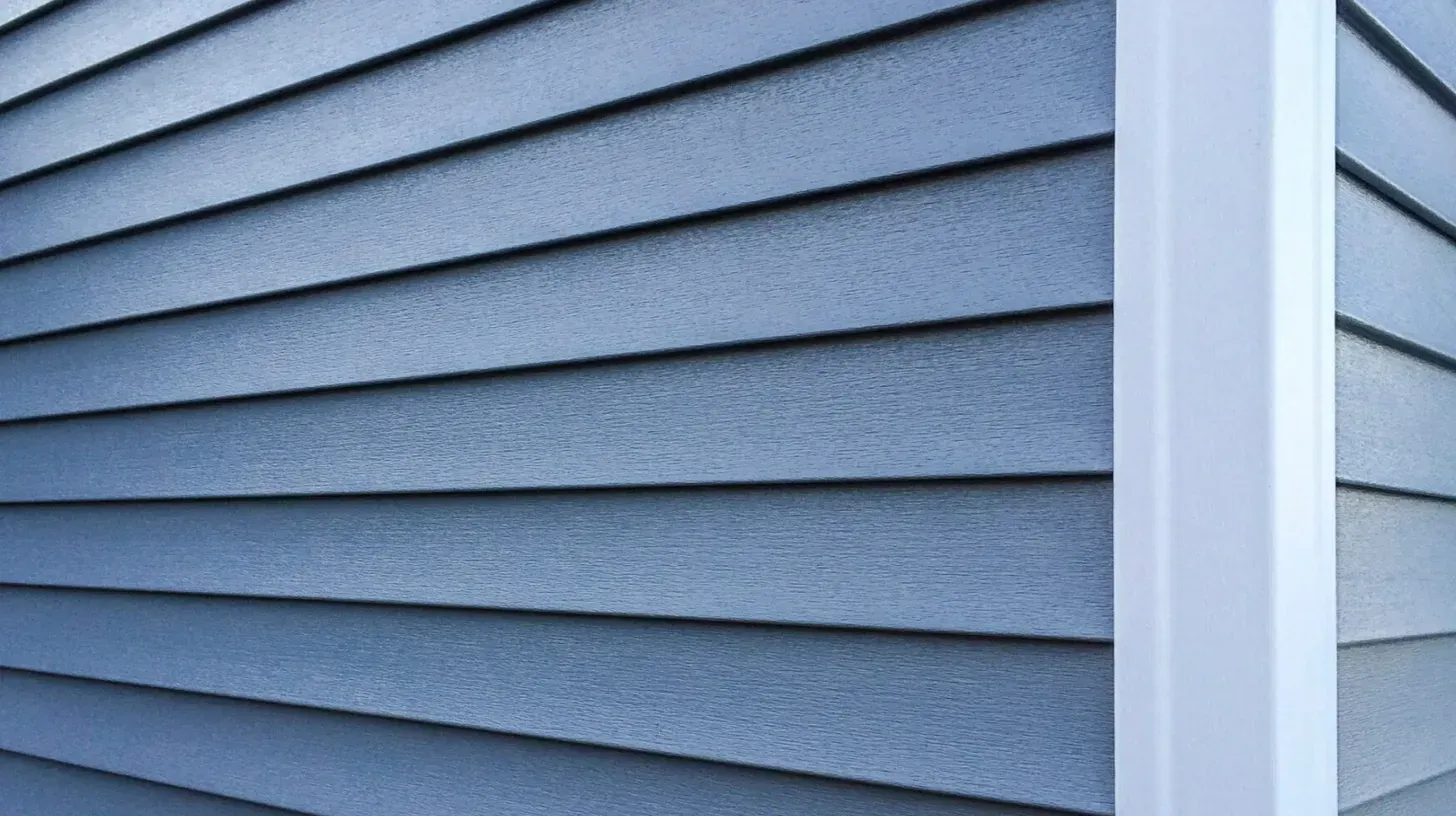 Blue vinyl siding with white trim on a house exterior