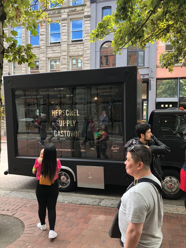 A black truck is parked on the side of the road in front of a building.