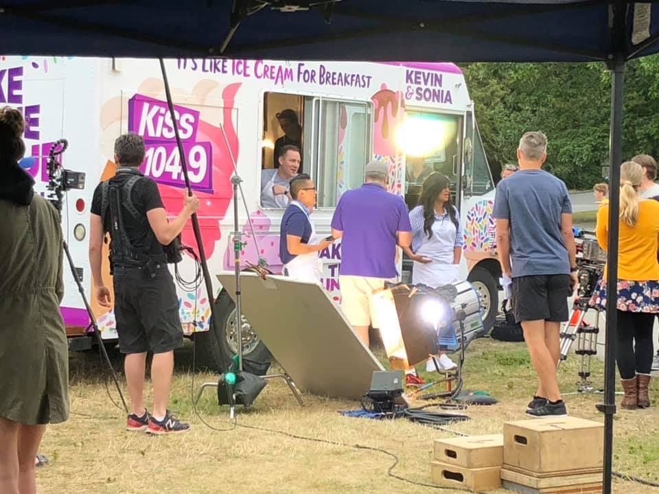 A group of people are standing in front of an ice cream truck.