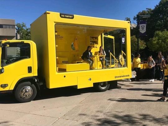 A yellow truck is parked on the side of the road.