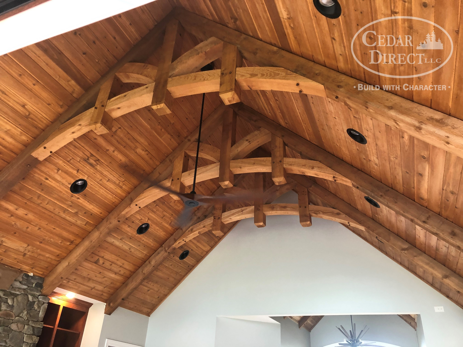 A wooden ceiling with a ceiling fan hanging from it