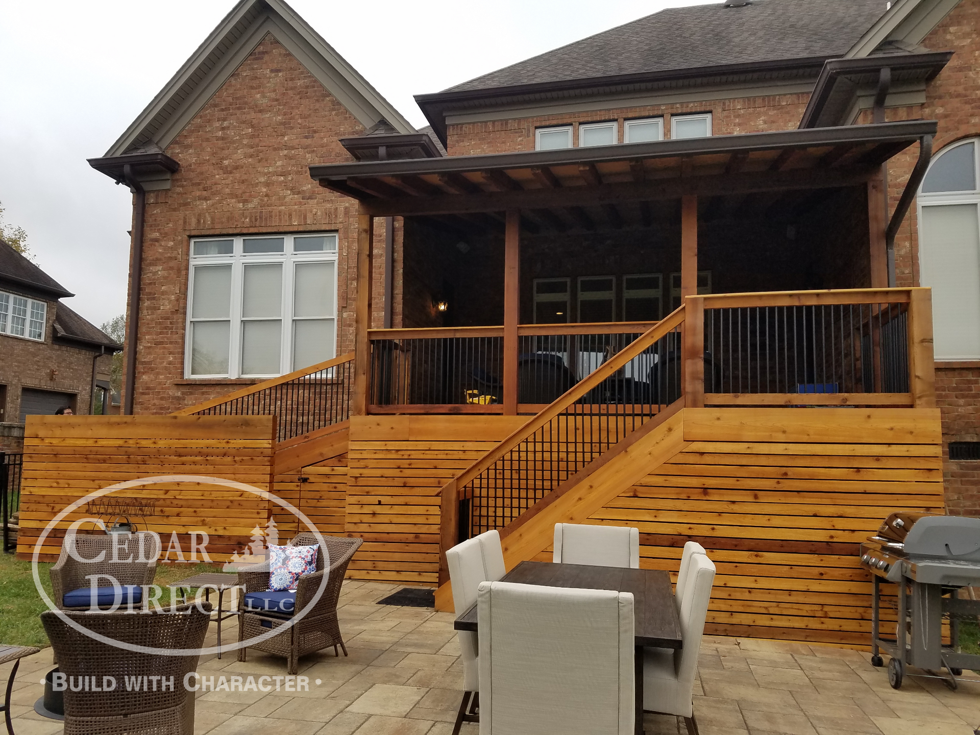 A large brick house with a wooden deck and stairs