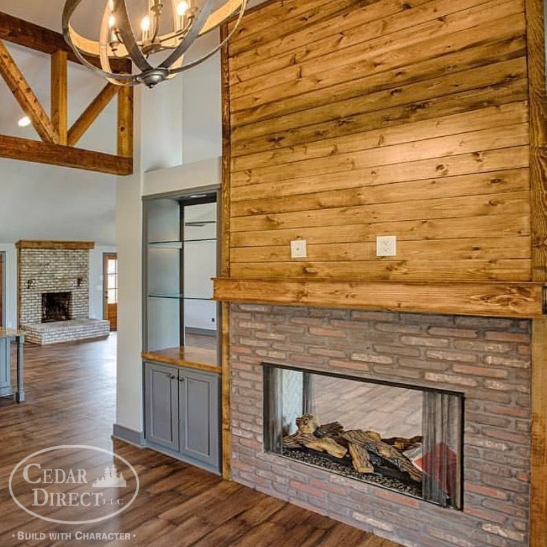 A living room with a brick fireplace and wood paneling