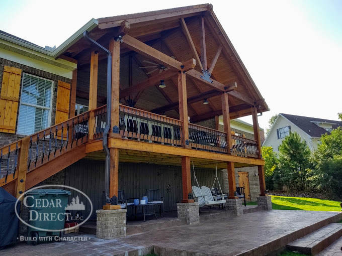 A house with a large wooden deck and stairs.