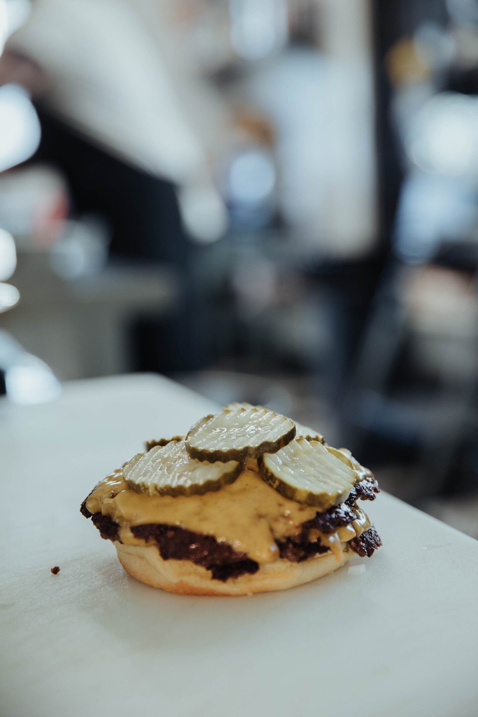 Assembling Denver's best cheeseburger with pickles