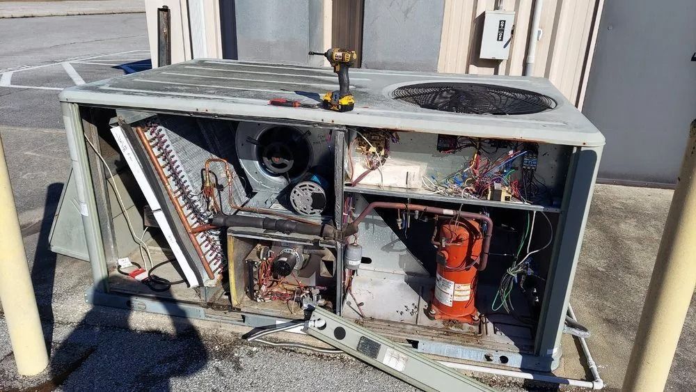 Open HVAC unit with exposed wiring and components inside a metal outdoor cabinet