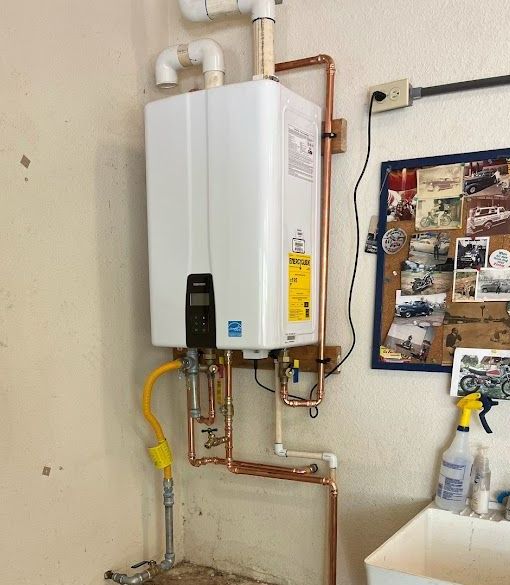 A white water heater is hanging on a wall next to a copper pipe.
