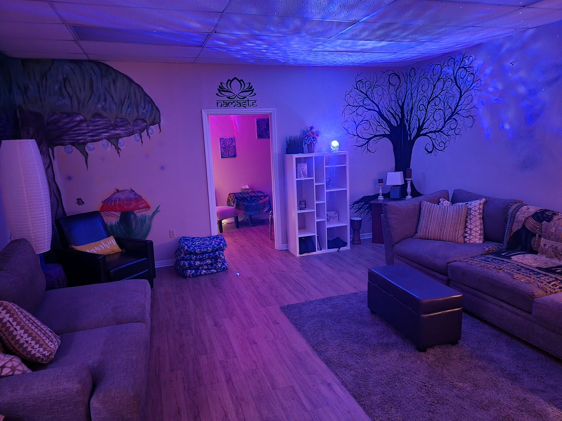 A living room filled with furniture and purple lights.