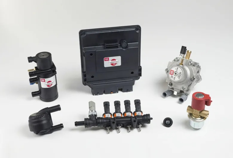 Vari componenti del sistema di alimentazione per autoveicoli, neri e argentati, disposti su sfondo bianco.