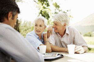 Senior Couple and Businessman Sitting at Outdoor Table